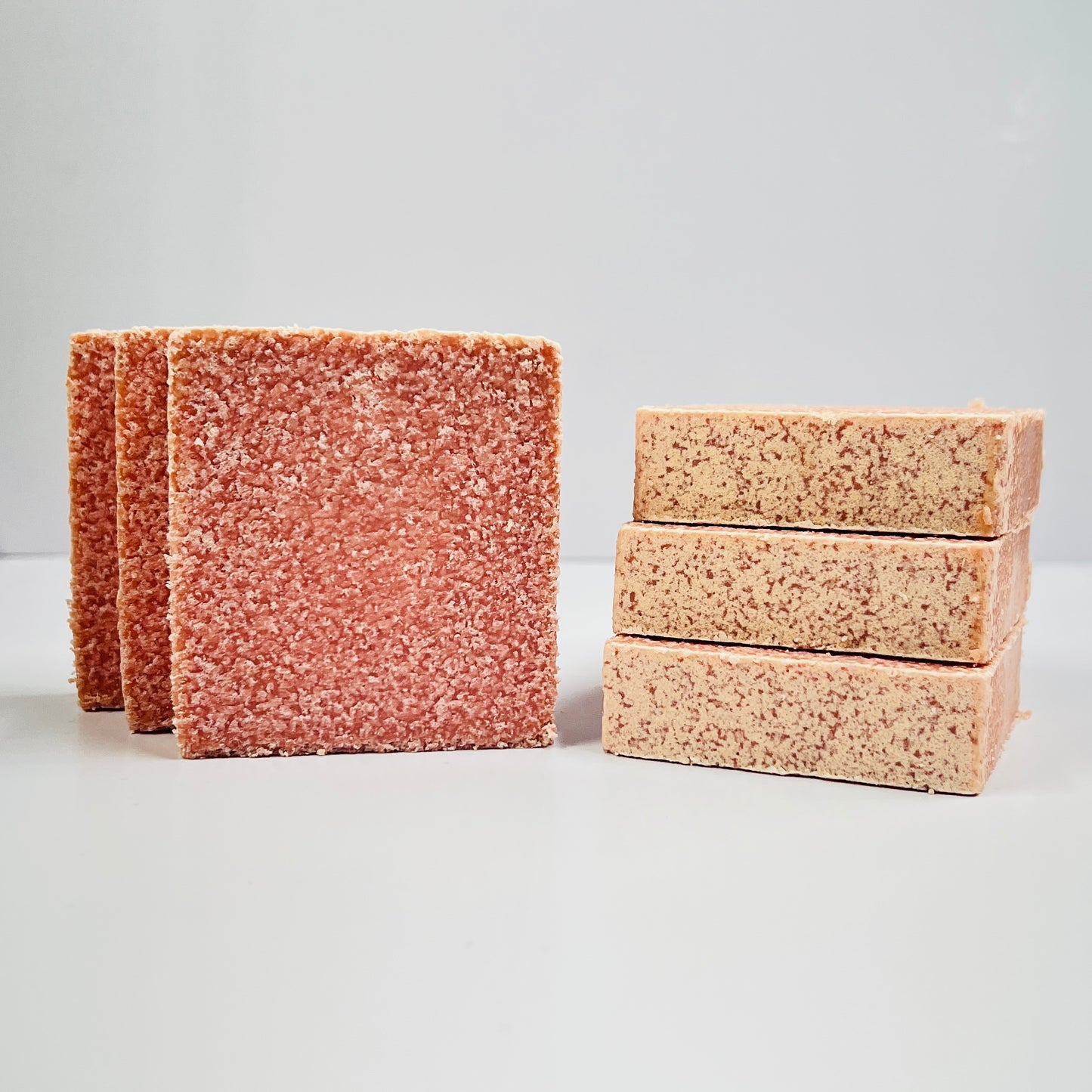 Two stacks of red and beige soaps on a light gray background