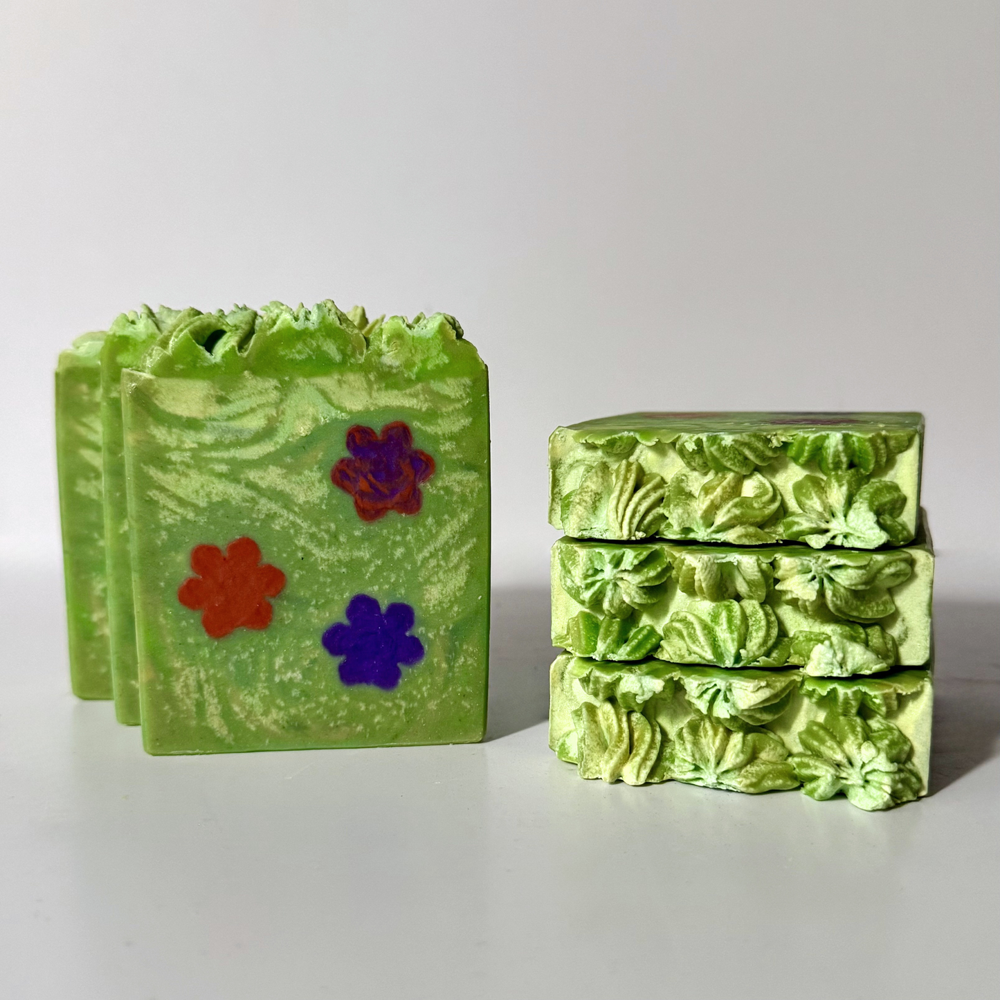 Green soap bars with floral designs on a light gray background