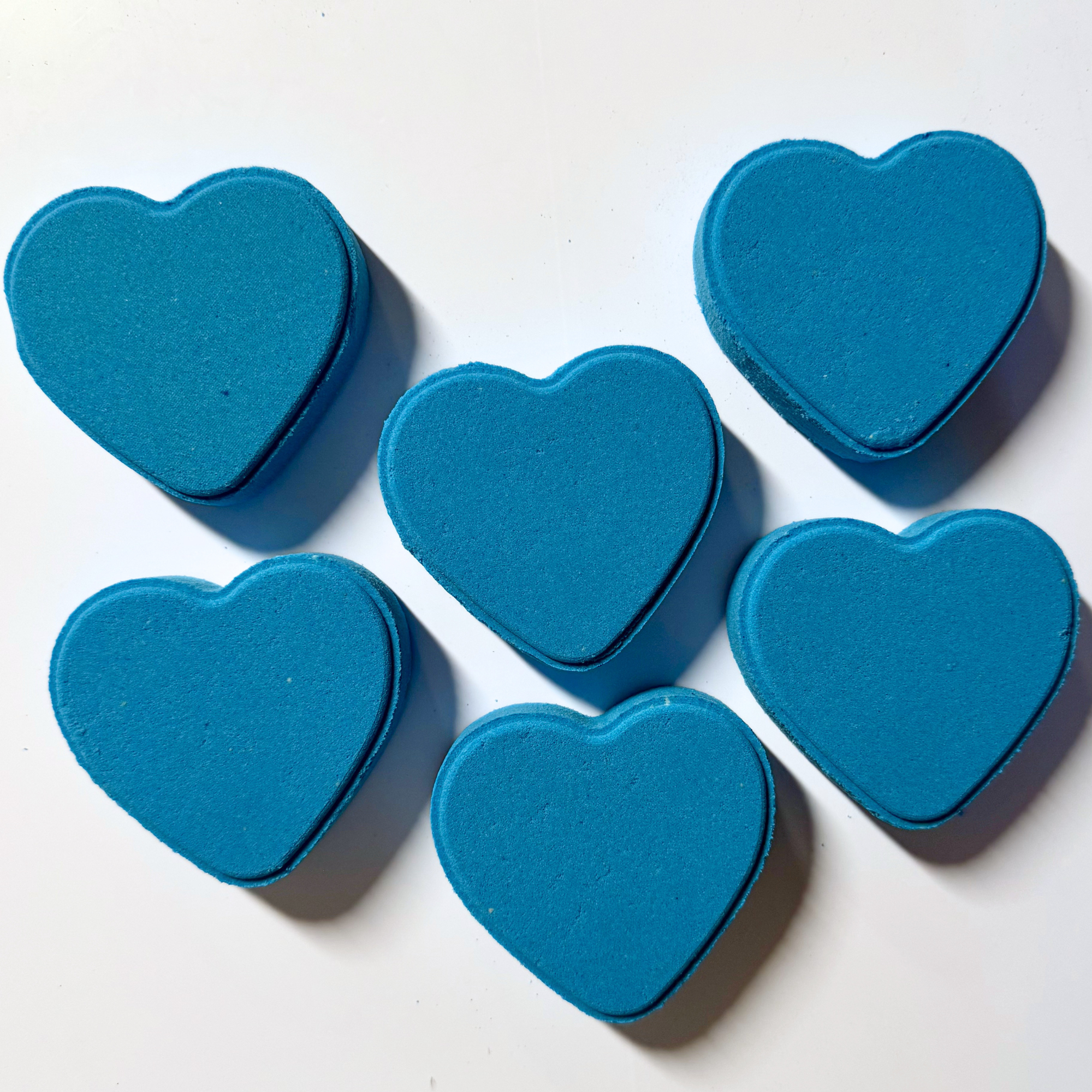 Six blue heart-shaped objects on a white background