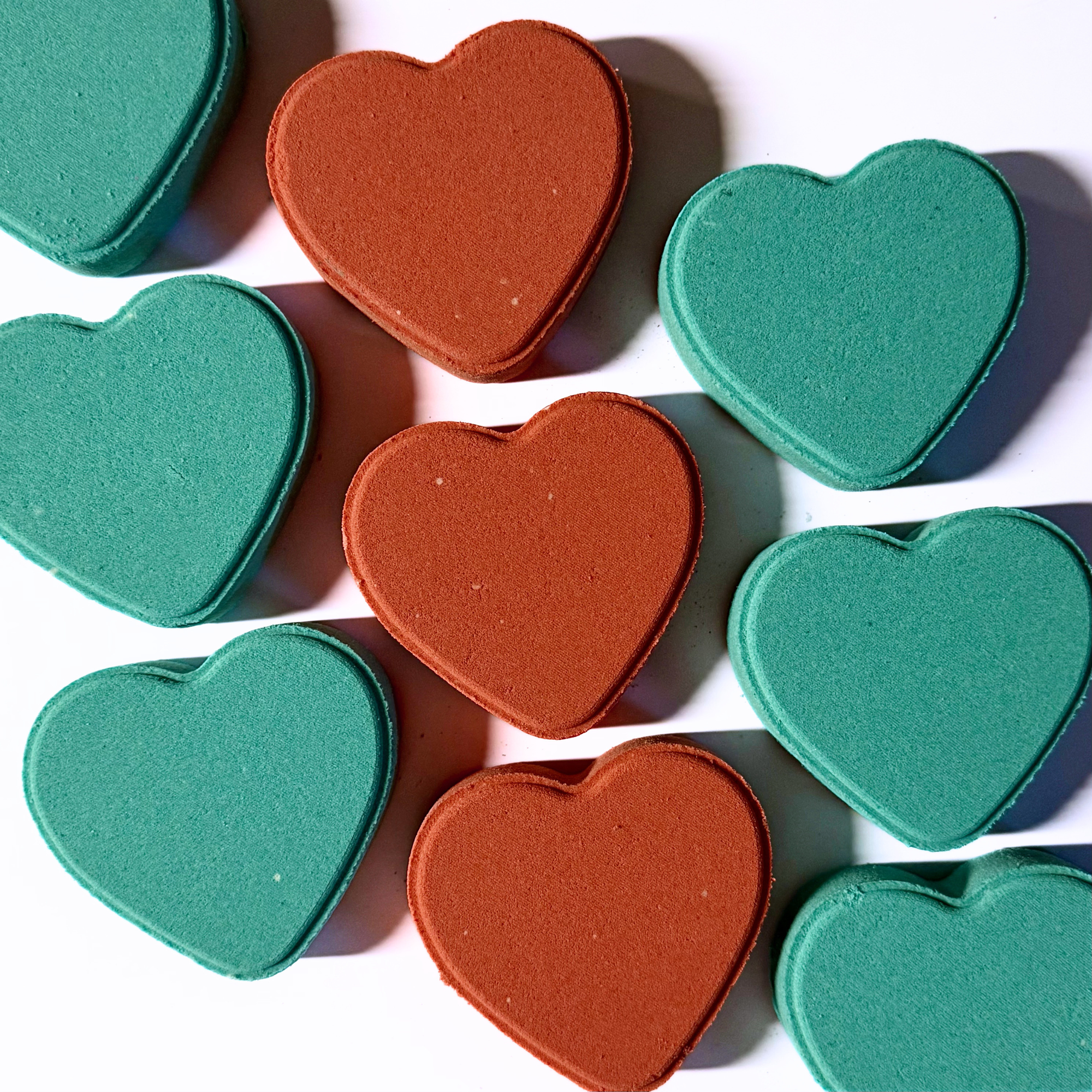 Heart-shaped objects in teal and brown on a white background