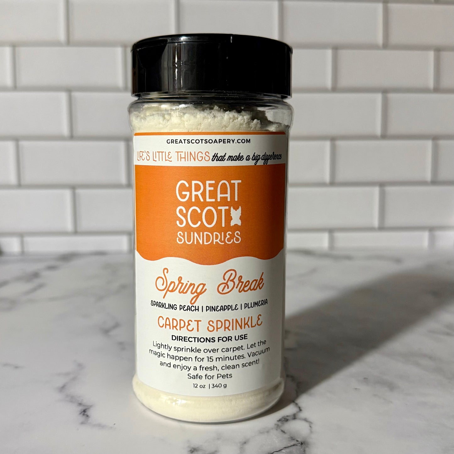 Jar of 'Great Scot Sundries' carpet sprinkle on a marble surface with a tiled wall background