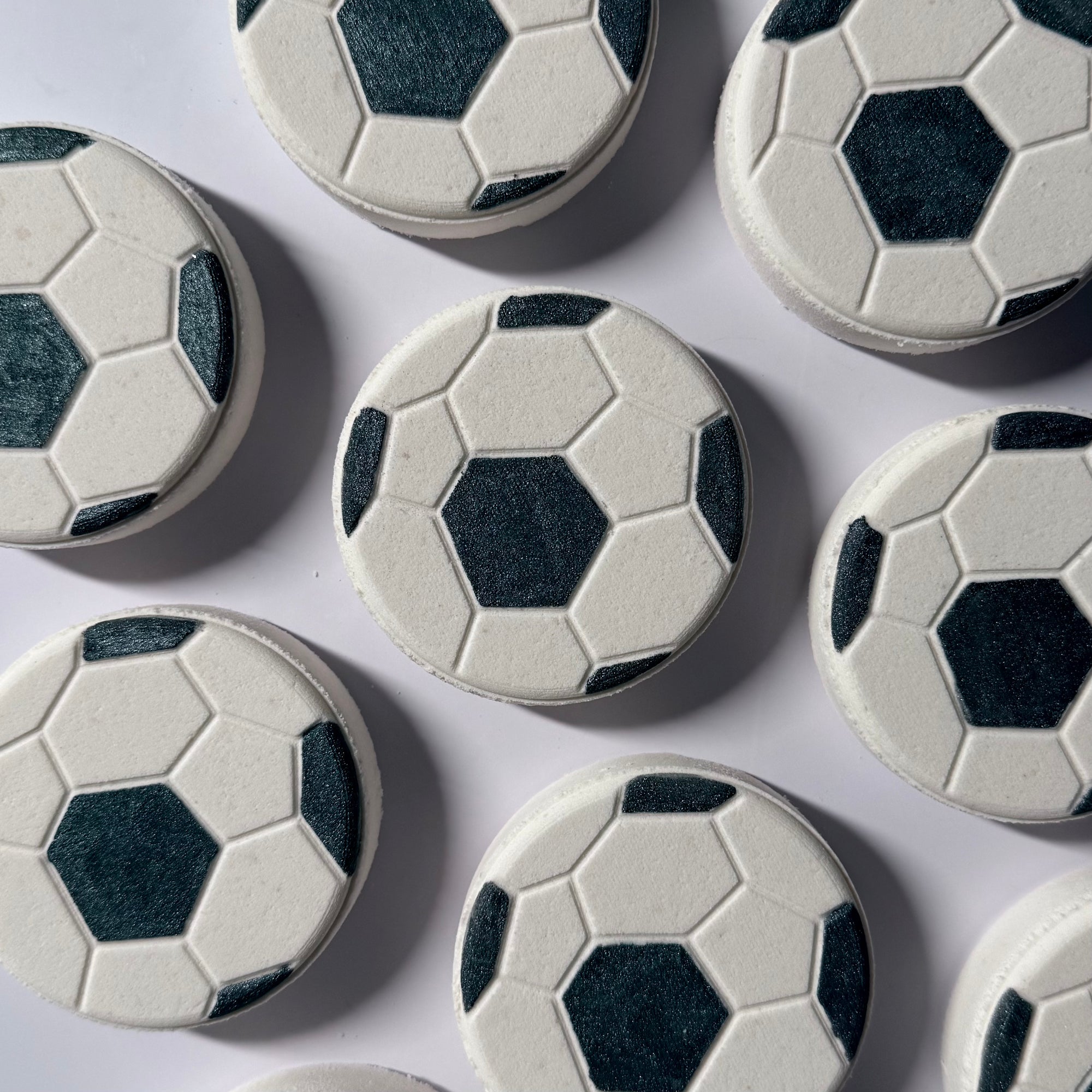 Soccer ball-shaped bath bombs on a white background