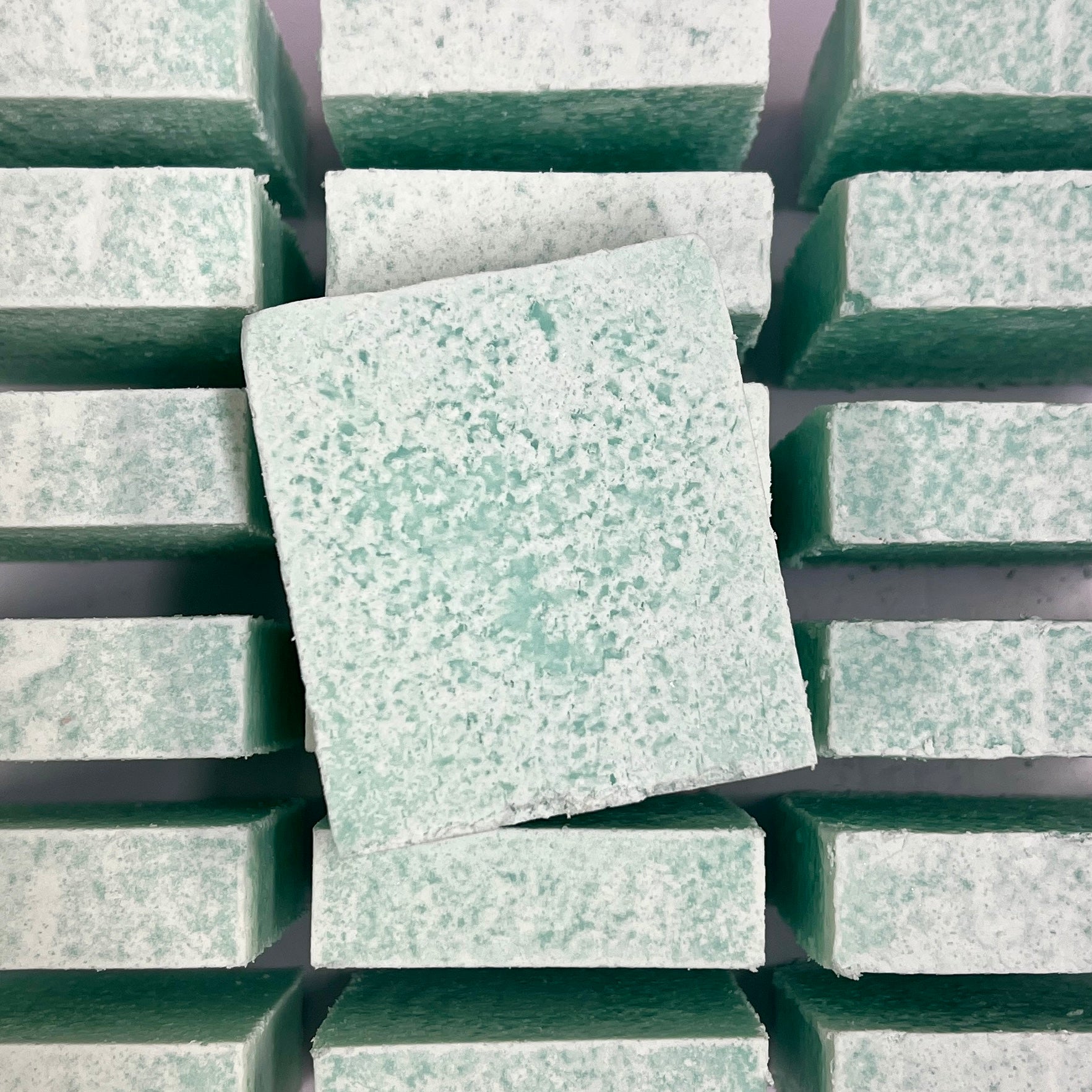 Green soaps stacked on a grid background