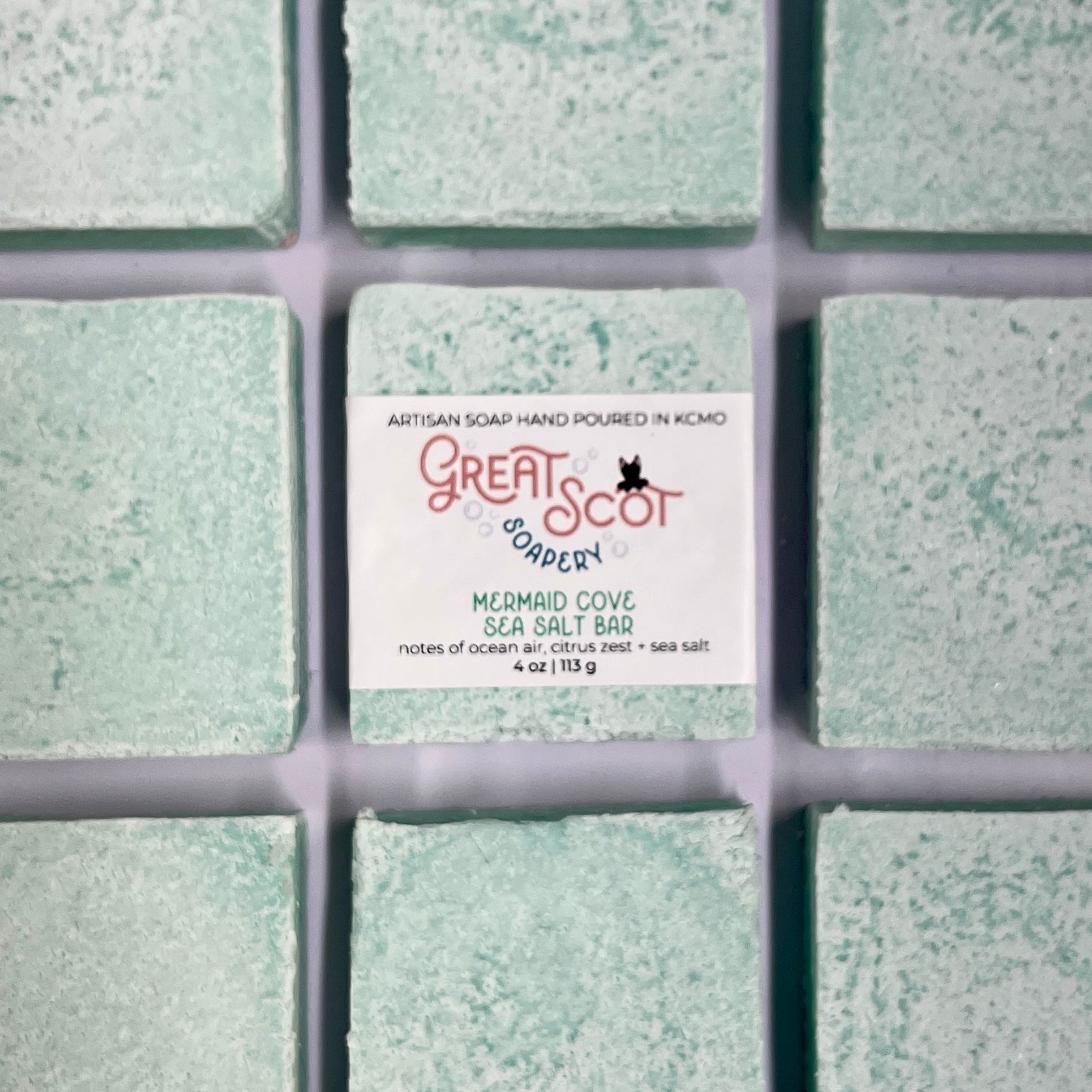 Green soap bar with 'Great Scot Soaps' label on a grid background