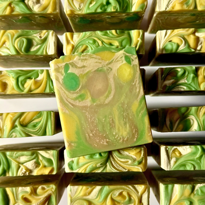 Green and yellow swirled soap bars stacked on a white background