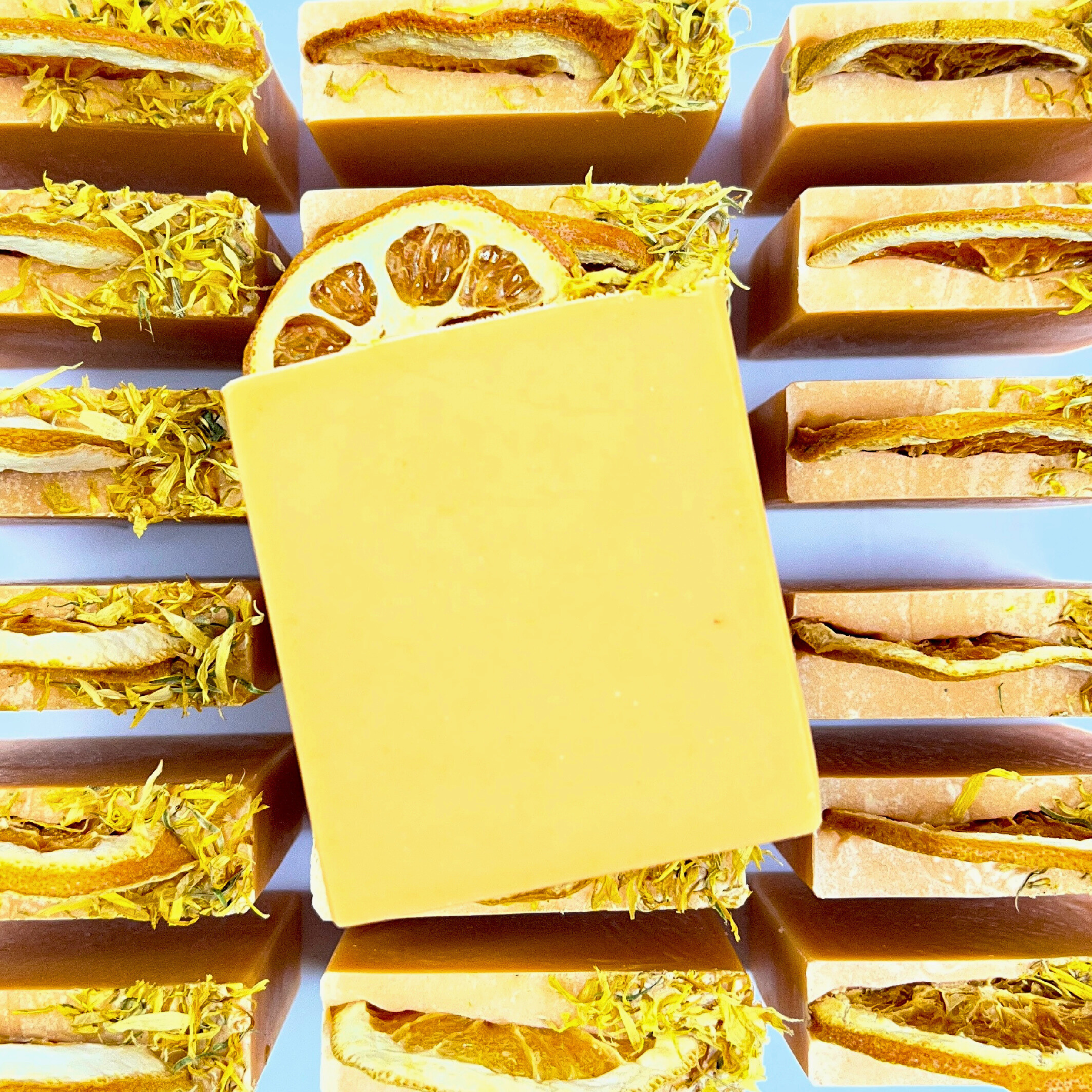 Multiple bars of soap with various ingredients on a blue background