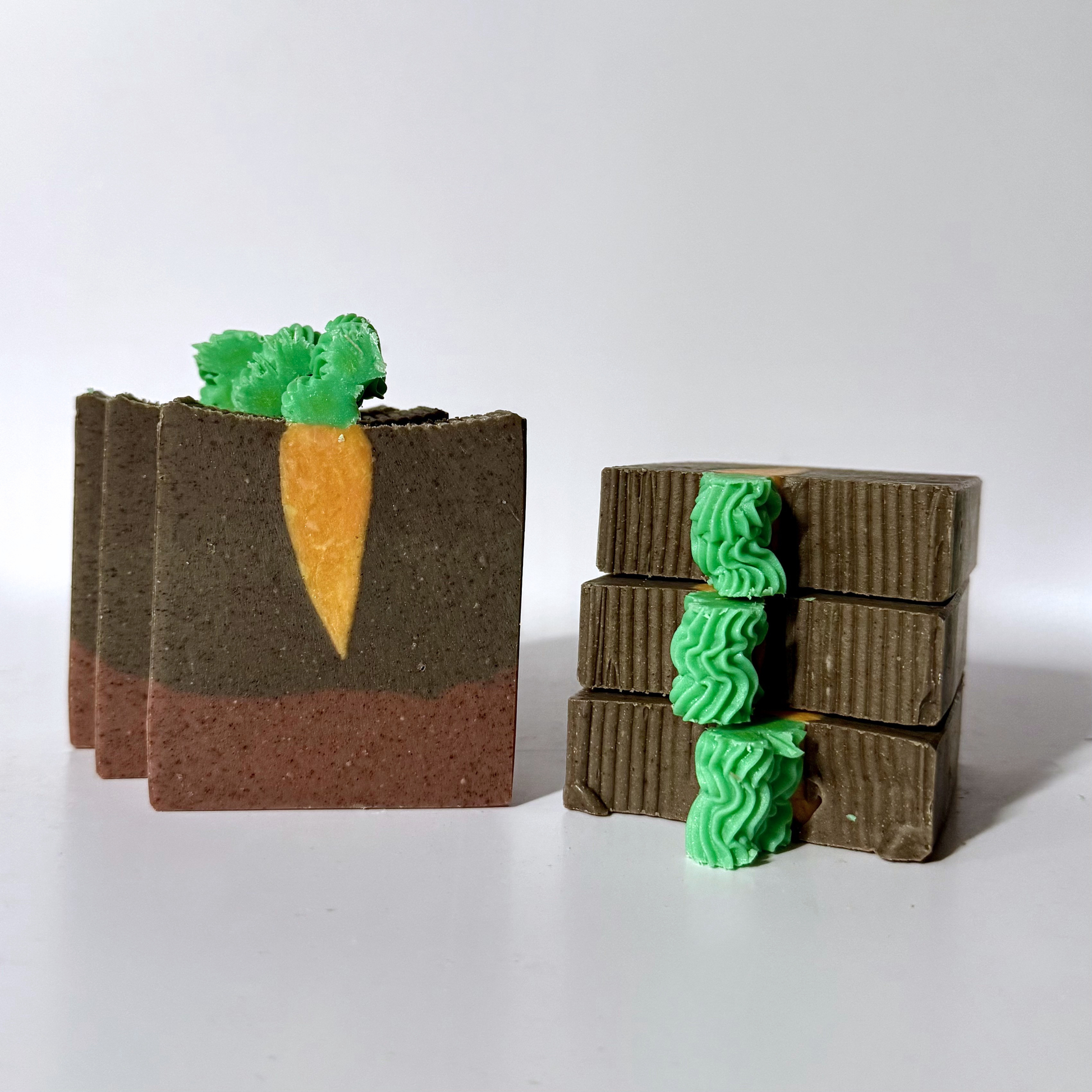 three soaps with carrot design in dirt