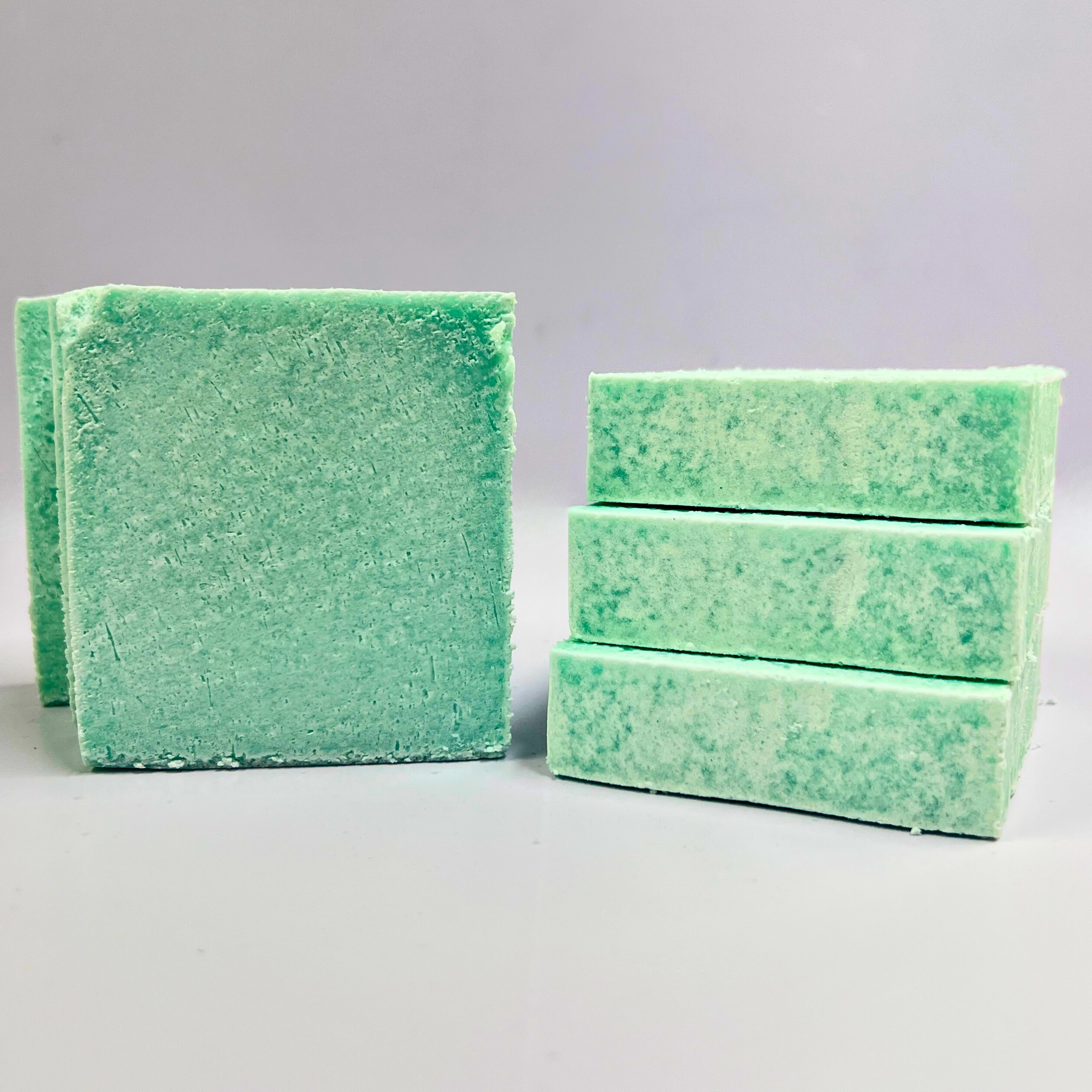 Green soaps stacked on a gray background