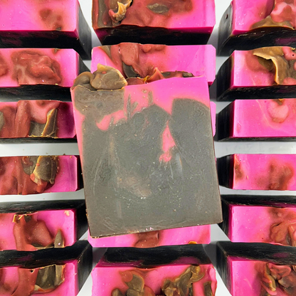 Bar of soap with pink and gold decorative elements on a reflective surface