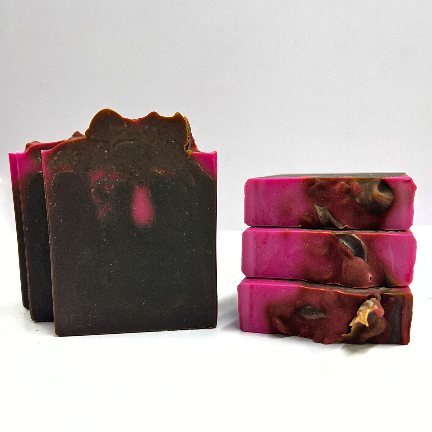 Two bars of soap with a marbled design in pink and brown on a white background