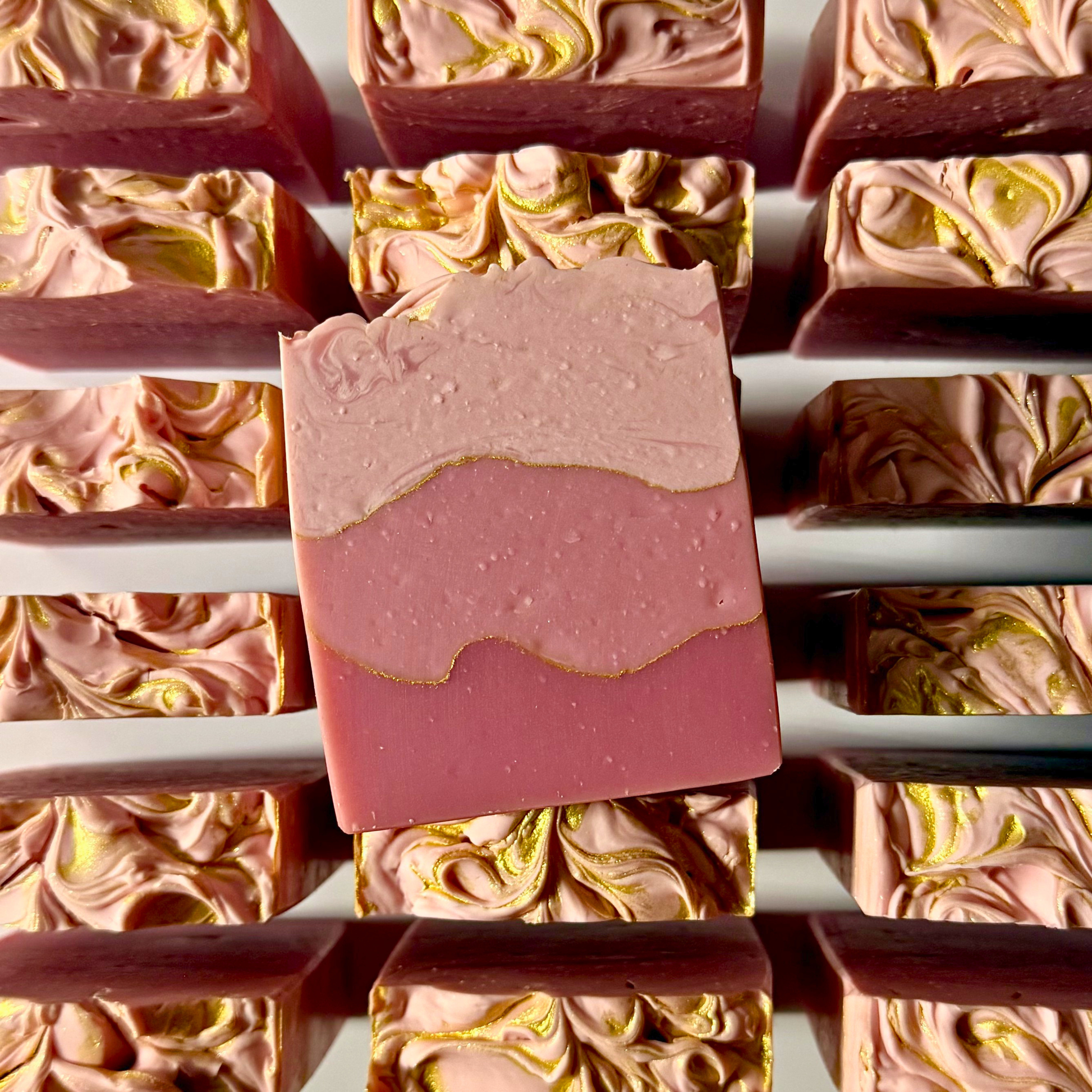 Pink and gold swirled soap bars on a white background