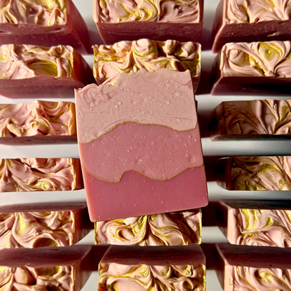 Pink and gold swirled soap bars on a white background