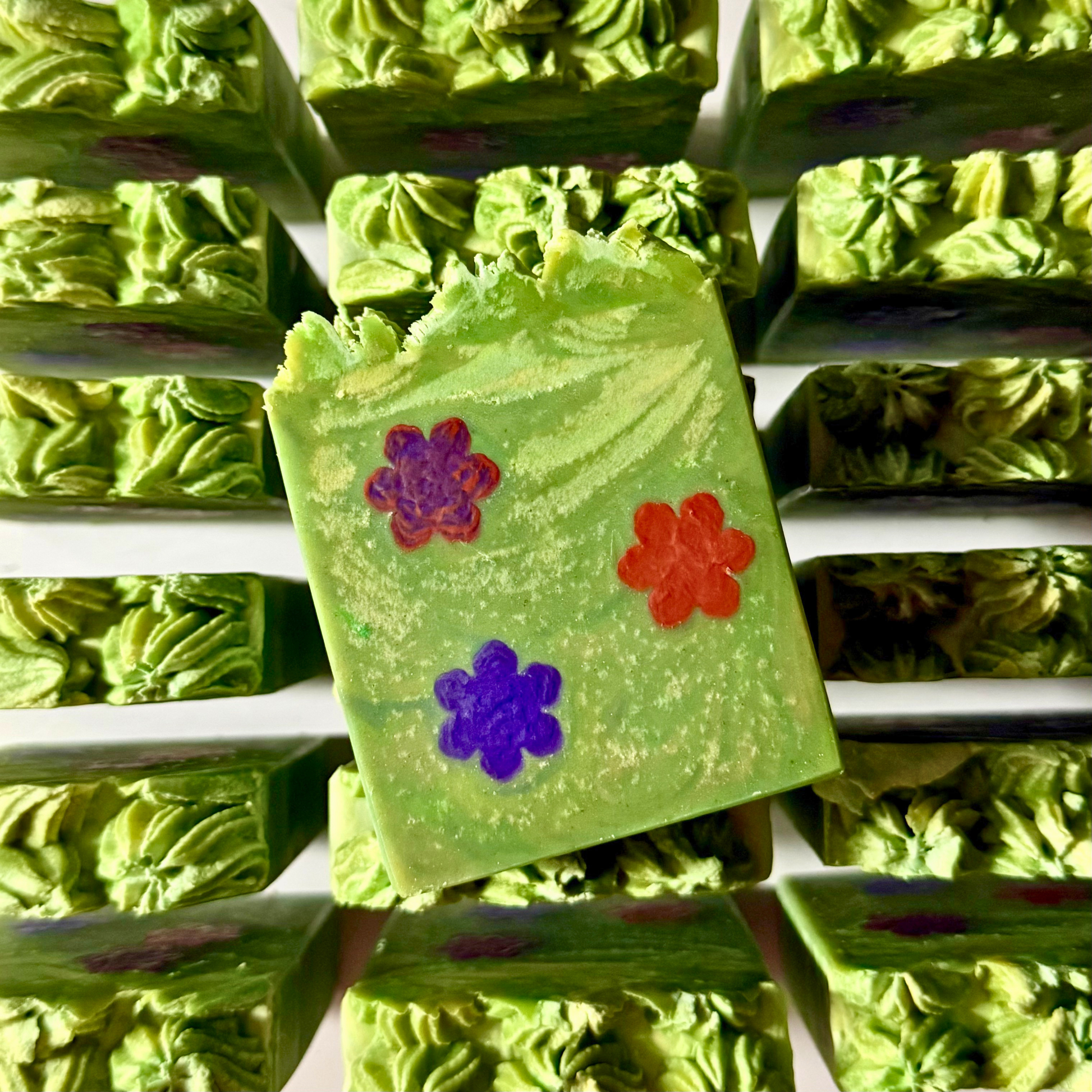 Green soap bars with colorful flower designs on a white background