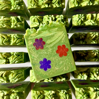 Green soap bars with colorful flower designs on a white background