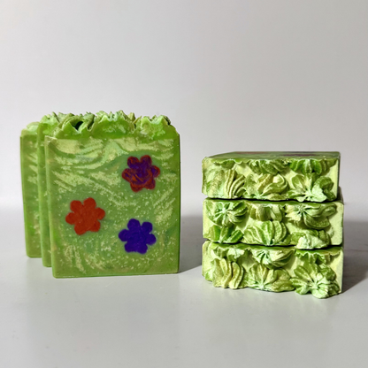 Green soap bars with floral designs on a light gray background